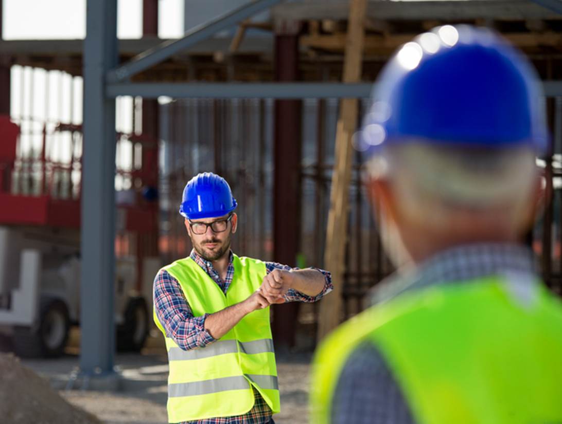 A person in safety vest and hardhats looking at his watch
AI-generated content may be incorrect.
